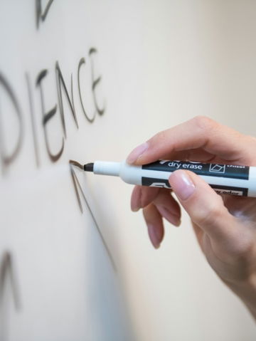 person holding white and blue click pen